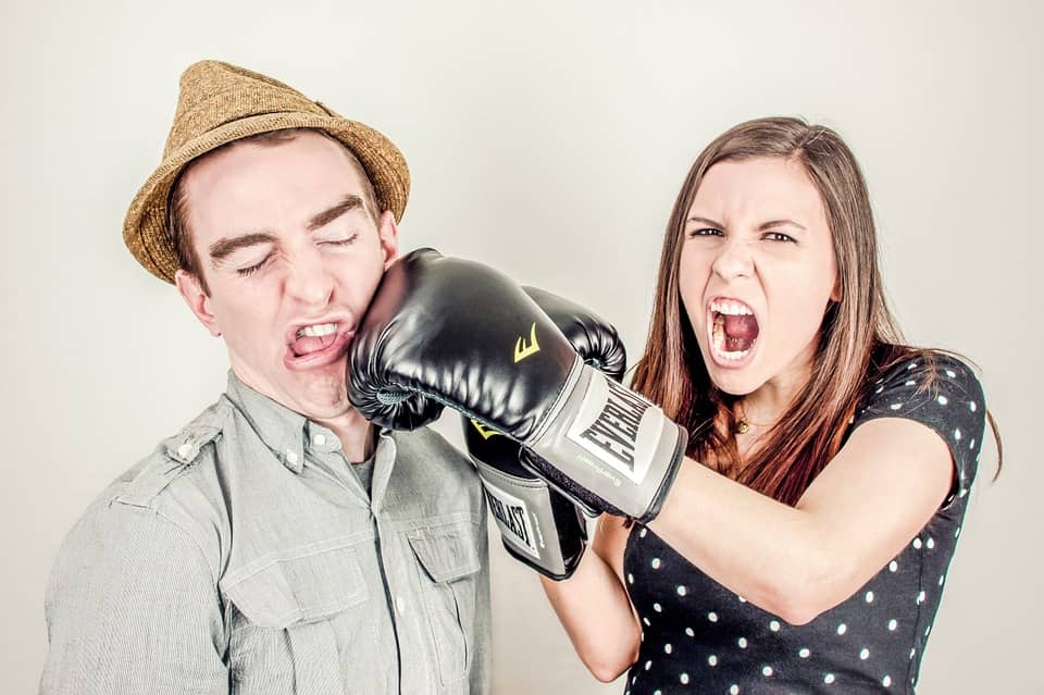 mulher socando um homem usando luvas de boxe