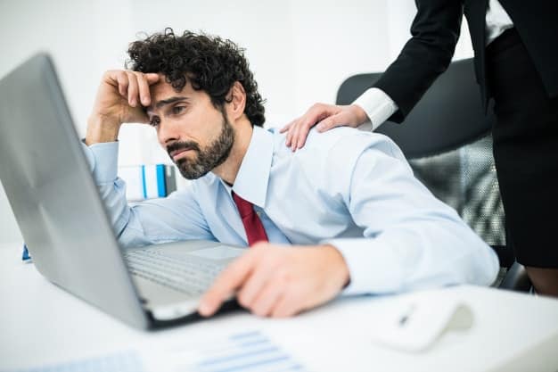 homem olhando triste para o computador