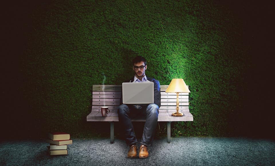 homem de óculos escrevendo no seu notebook
