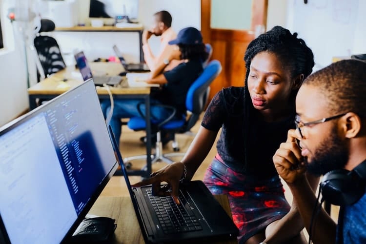 um homem e uma mulher olhando juntos para a tela de um computador