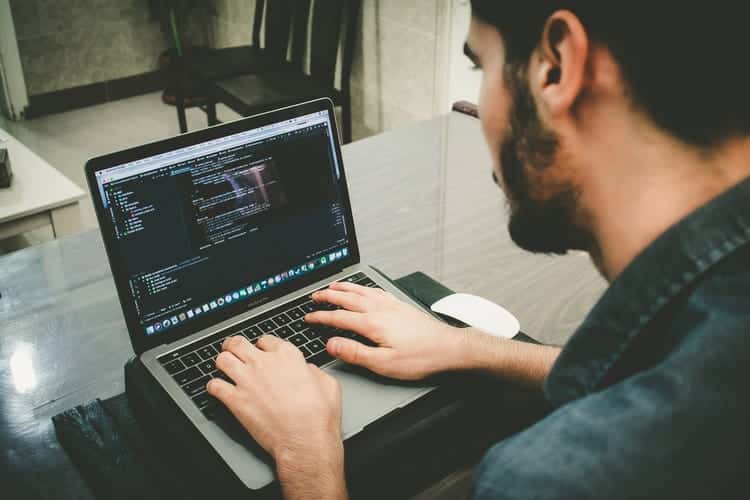 homem usando o computador com codigos de programacao