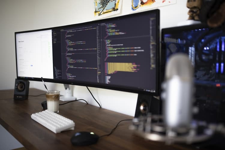 tres telas de computador com codigos de programacao