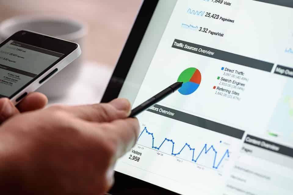 pessoa apontando para um grafico em um tablet