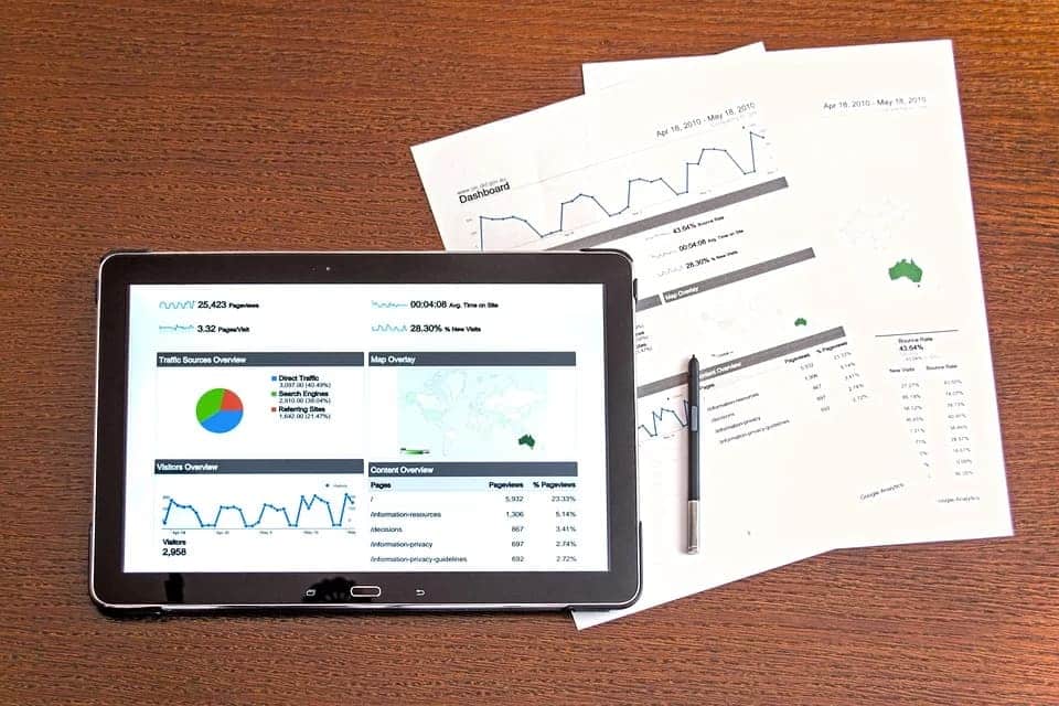 imagem de tablet e papel com graficos
