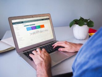 Pessoa com as mãos sobre um notebook com gráficos de desempenho
